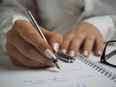 pexels photo 110473 110473 A detailed image of handwriting in a notebook with a fountain pen and glasses, ideal for office themes.