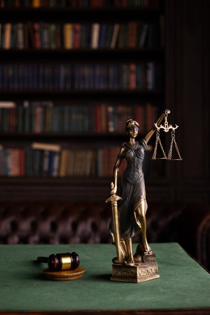 pexels photo 6077123 Lady Justice and gavel on a table in a classic law library setting.